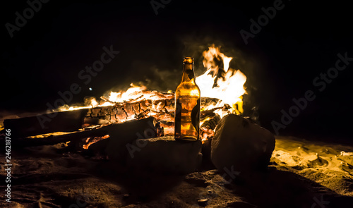 Fire flames abstract texture pattern background concept. Beer bottles and campfire isolated on dark black background. Wood fire flames collection smoke on warm beach night. Flame and fire sparks.