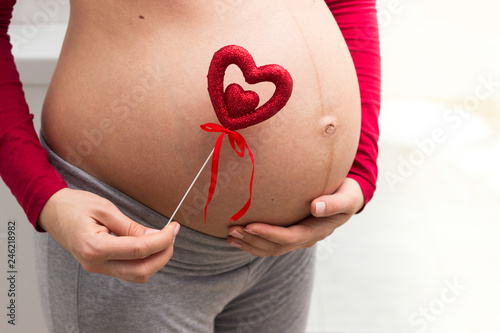 Wallpaper Mural Pregnant woman holding red heart to one side  Torontodigital.ca
