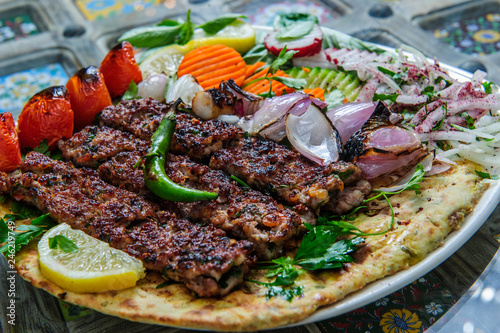 Plate of arabic kebab meat with grilled vegetables.