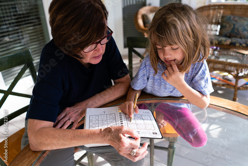 Grandmother and granddaughter doing a math puzzle photo