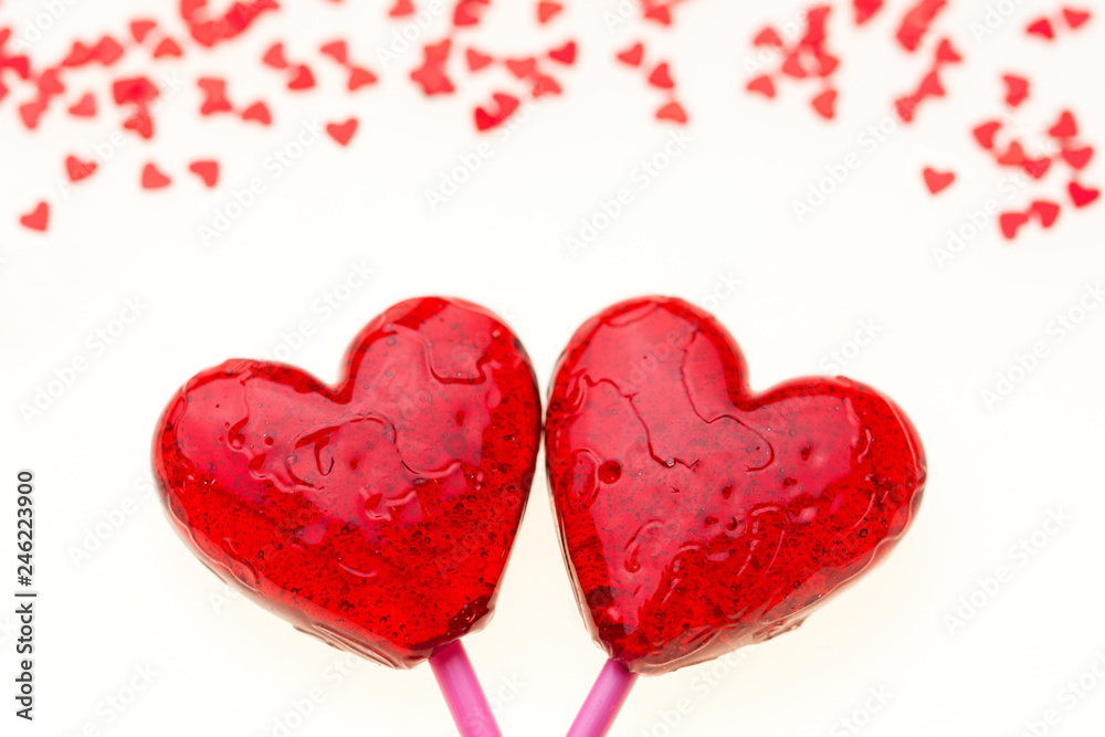 Valentine card with two big red lollipop hearts and many small red hearts at the top, white background