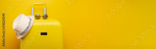 Banner yellow suitcase, with a hat for recreation, the beach and sunglasses. Travel Things Concept Festive Adventure Travel, on yellow background