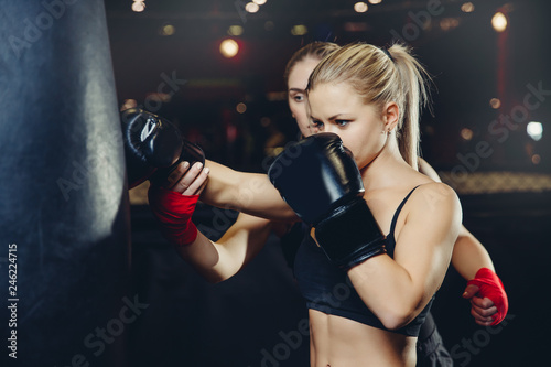 Young woman boxing trainer has been training with girl in gym
