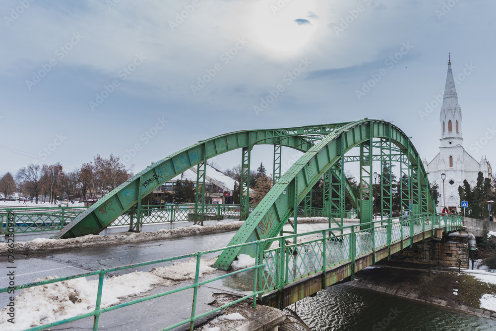 an old green bridge on a lake in the city center