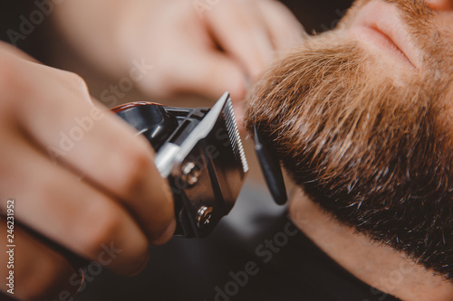 Macro Man hipster having barber shave barbershop hair machine photo
