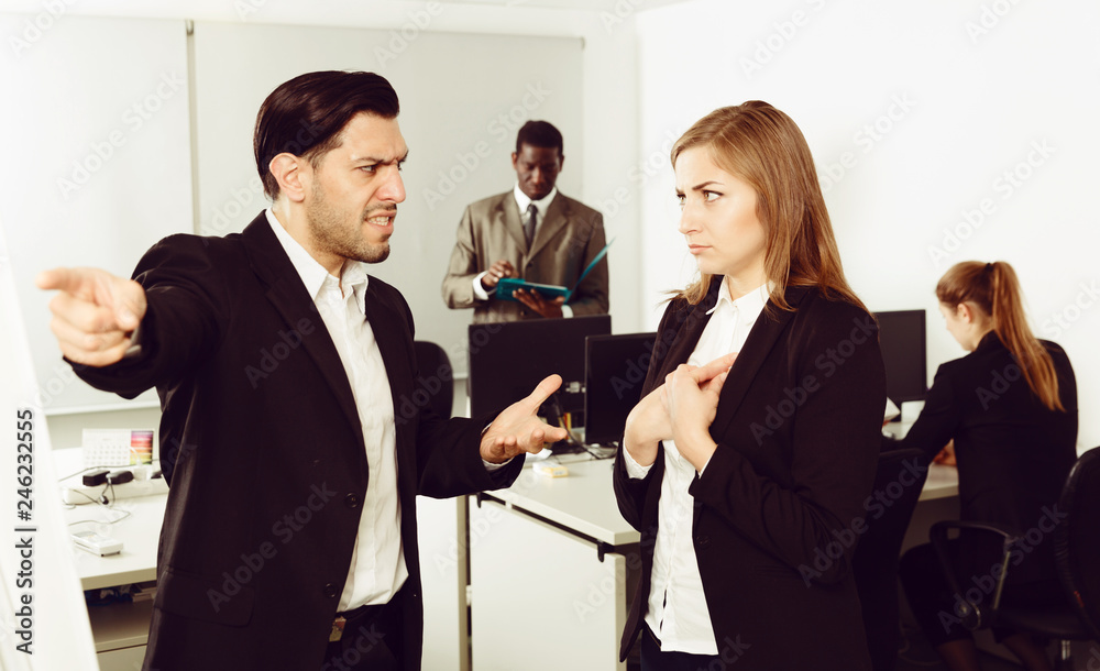 Obraz premium Male boss pointinting to misses in work to woman manager