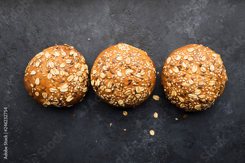 Wholegrain burger buns on dark background. Top view, space.