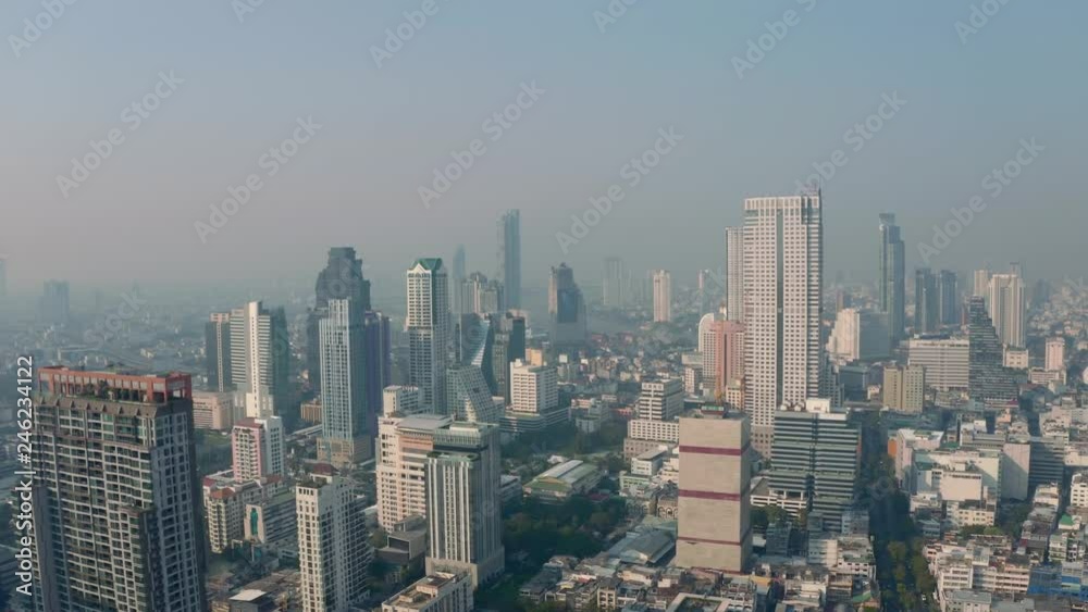 Bangkok central business downtown, heavy traffic aerial view. Top view of hazy Thailand's capital. Big city life, transportation, infrustructure and developing country concept. Bangkok central business downtown, heavy traffic aerial view. Top view of hazy Thailand's capital. Big city life, transportation, infrustructure and developing country concept.