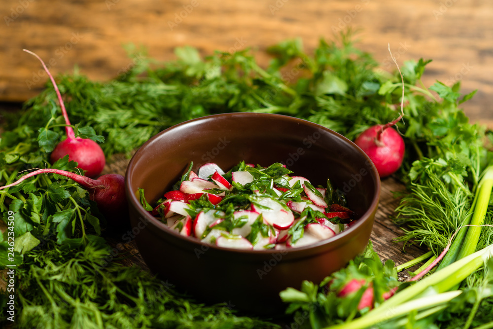 radish salad with green onions in a clay plate on a wooden board radish salad with green onions in a clay plate on a wooden board