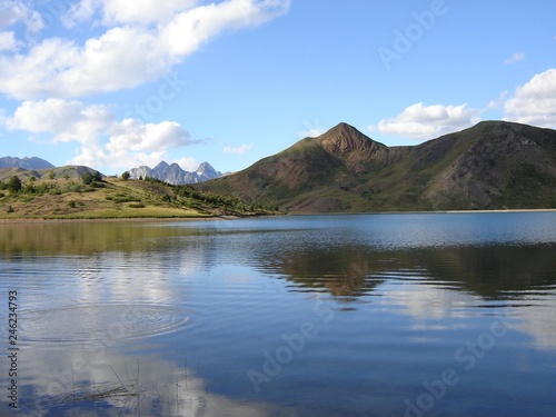 Mountains reflected in rippling peaceful lake waters. Ibón de Tramacastilla (Tramacastilla lake), Huesca, Spain