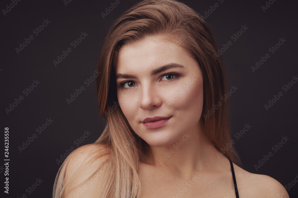 Young beautiful woman against dark background