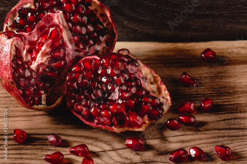 Fotografi pomegranate seeds, red half pomegranate on wooden background, with copy paste sp