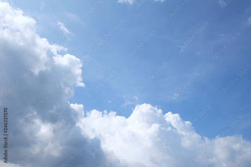 Fototapeta premium White fluffy clouds with blue sky and sun light for background texture 