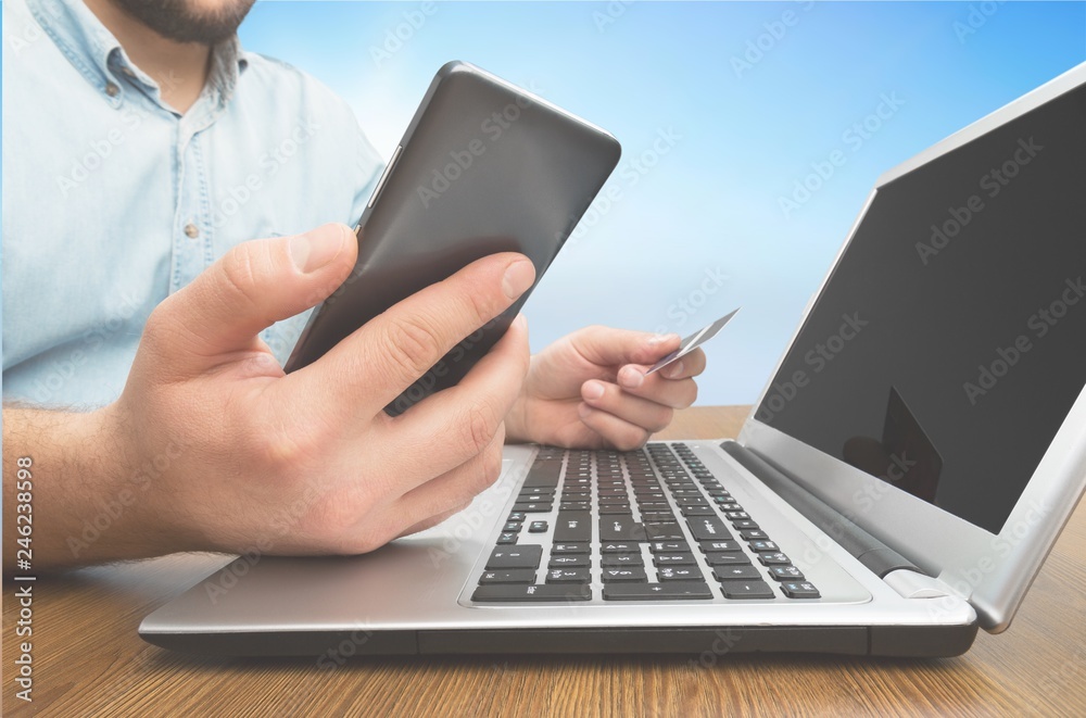 Man holding a credit card and typing. On-line shopping on the Man holding a credit card and typing. On-line shopping on the