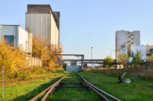 Railway tracks in the industrial zone of the plant. View of the building of the elevator of the bakery