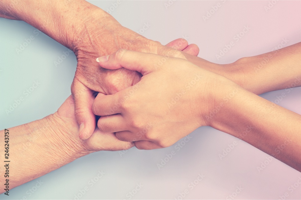 Fototapeta premium Hands of the old man and a young woman. close up.