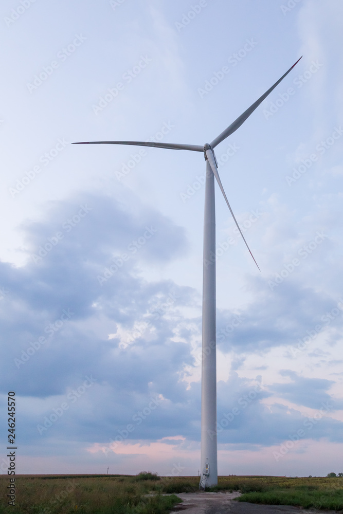 One windmill turbine at blue and purple cloudy sunset sky