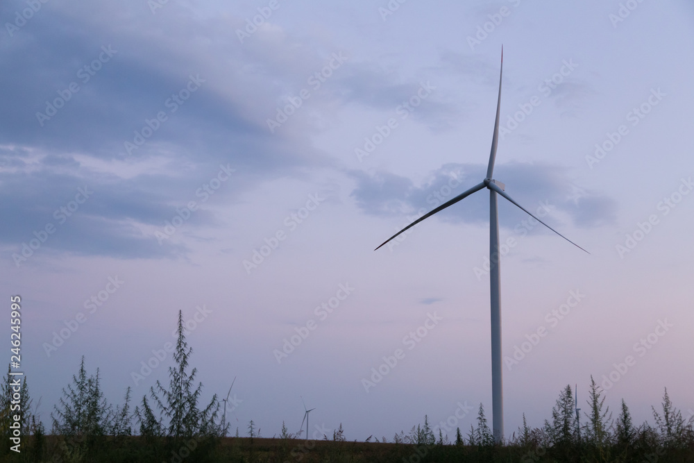 One windmill turbine at blue and purple cloudy sunset sky One windmill turbine at blue and purple cloudy sunset sky