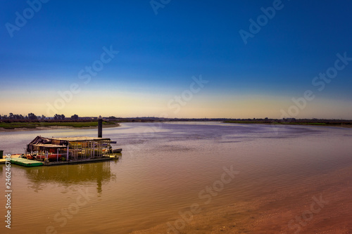 Fototapeta Naklejka Na Ścianę i Meble -  Landscape of a pier in a wide river.