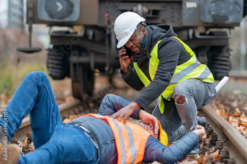 Railroad engineer injured in an accident at work on the railway tracks. Calling for help