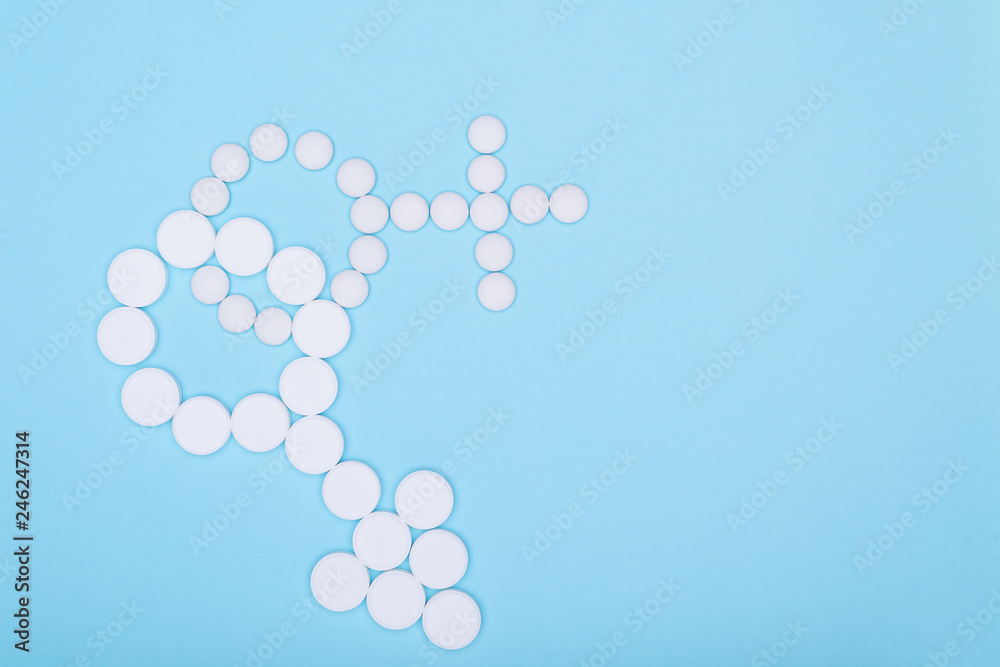 Concept of treatment of male and female genital disorders.Gender symbols of man and woman from white pills on blue background. Copy space for text. Concept of treatment of male and female genital disorders.Gender symbols of man and woman from white pills on blue background. Copy space for text.