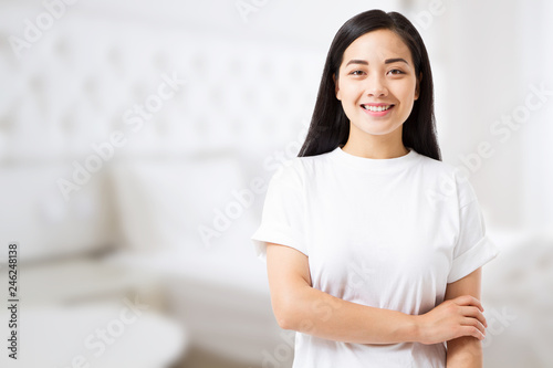 Smiling young asian woman with perfect skin care and template t shirt at home background. Blank t shirt and summer concept. Copy space