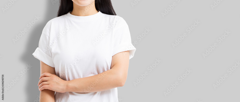 Asian girl in blank template t shirt isolated on gray background. Young woman in tshirt copy space and mock up for advertising. White shirts. Front view. Cropped image Asian girl in blank template t shirt isolated on gray background. Young woman in tshirt copy space and mock up for advertising. White shirts. Front view. Cropped image