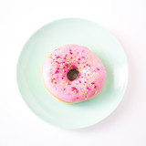 Pink Iced donut on a colourful plate
