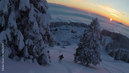 Wide angle shot of skier going downhill on sunset