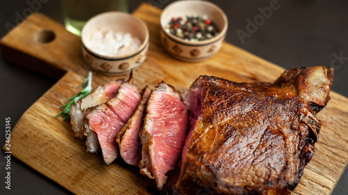 delicious steak, seasonings, a delicious piece of meat, cooked dinner on a concrete background