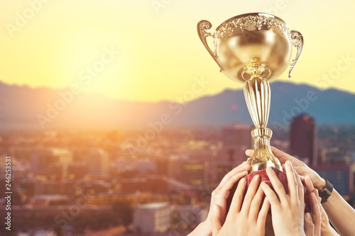 Hands holding a champion golden trophy on white background