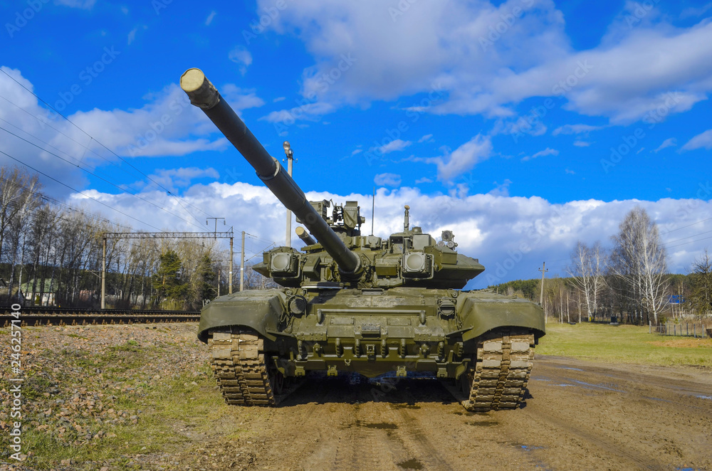 Russian armored tank in green camouflage against a blue blue sky. The gun looks menacingly to the top. Russian armored tank in green camouflage against a blue blue sky. The gun looks menacingly to the top.