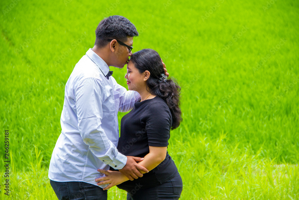 Portrait of a man kiss her pregnant wife, countryside landscape Portrait of a man kiss her pregnant wife, countryside landscape