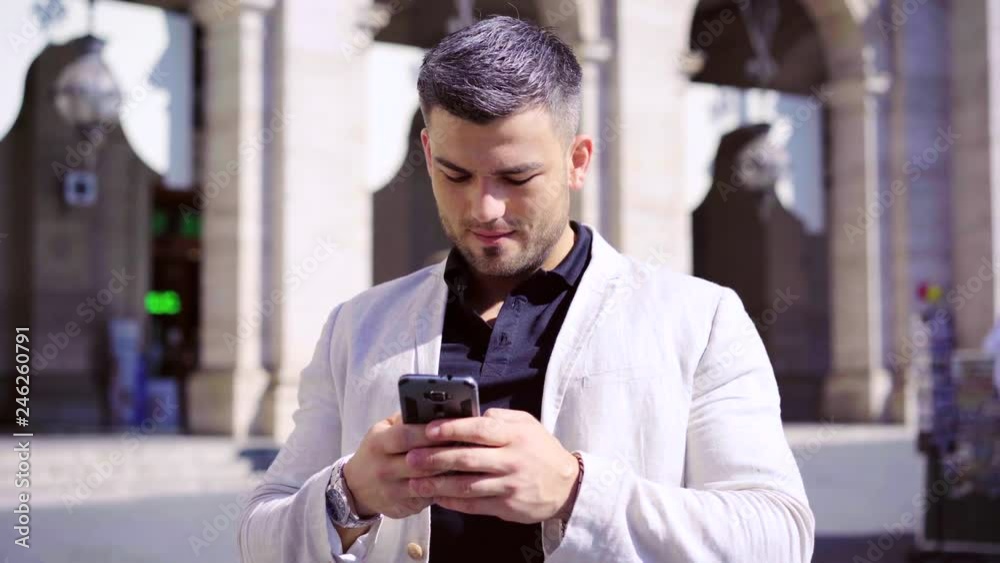 Man in white jacket texting message in a sunny summer day. 4K Man in white jacket texting message in a sunny summer day. 4K