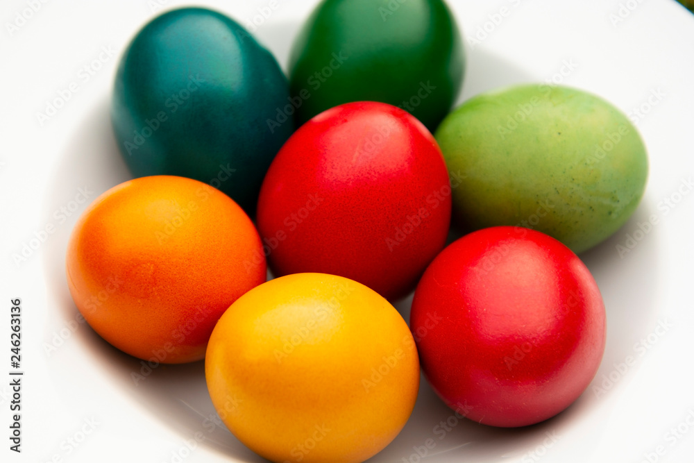 Easter eggs pile in white plate. Colorful, red, green ,blue, yellow and orange eggs. Top view. Easter eggs pile in white plate. Colorful, red, green ,blue, yellow and orange eggs. Top view.