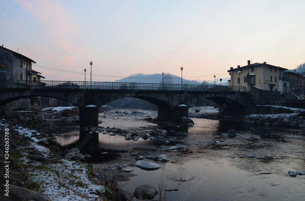 Gray, winter arched bridge in the commune of Barghe