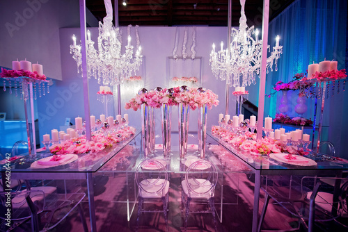 Fotografija High end wedding tablescape with pillar candles and pink orchids and chandelier