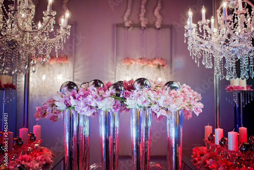 Fotografija High end wedding tablescape with pillar candles and pink orchids and chandelier