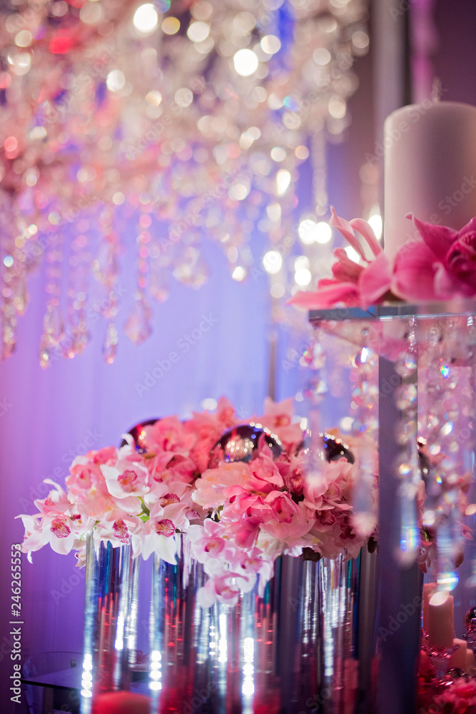High end wedding tablescape with pillar candles and pink orchids and chandelier High end wedding tablescape with pillar candles and pink orchids and chandelier