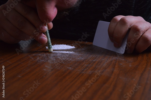 Tableau sur toile Person with a dollar bill snorting cocaine