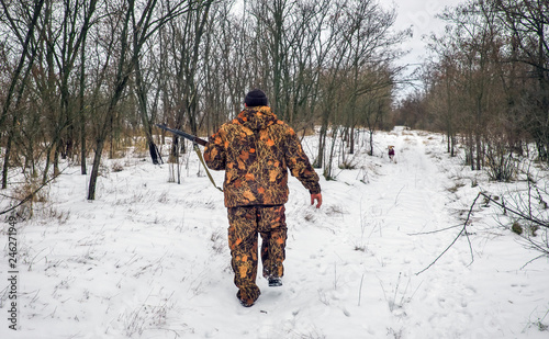 Winter hunting. Hunter moving With rifle and Looking For Prey.