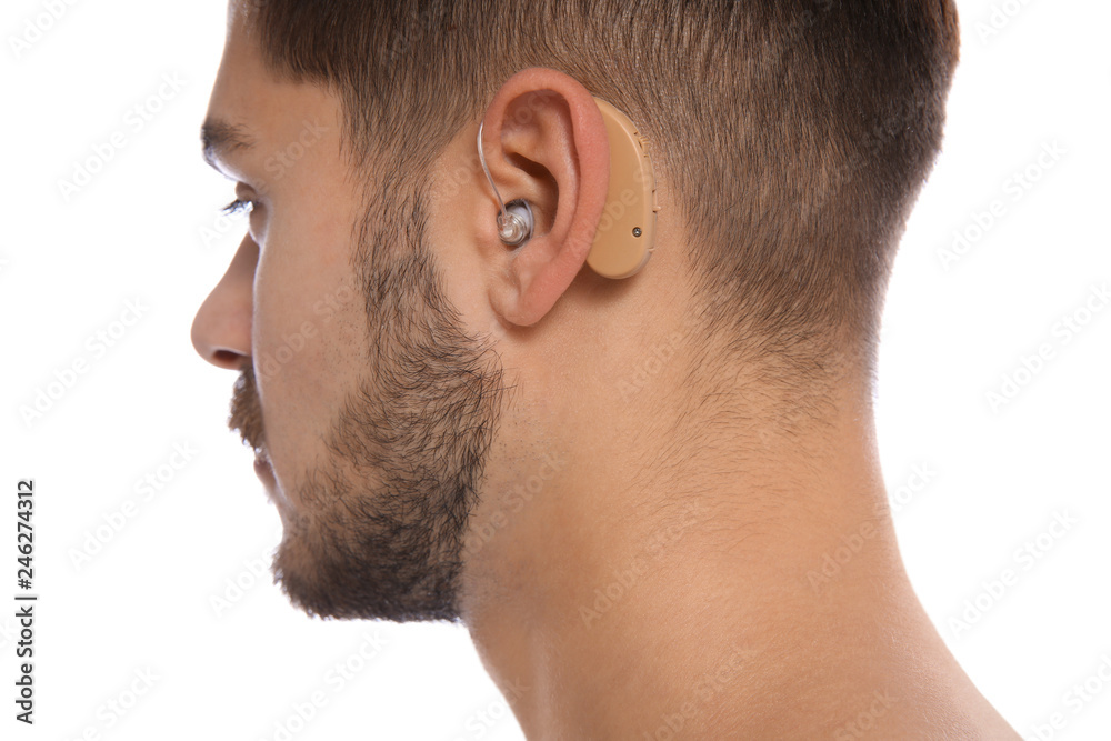 Fototapeta premium Young man with hearing aid on white background