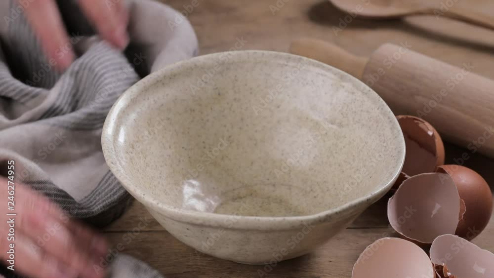 cook puts a tablecloth or linen towel on the kitchen table