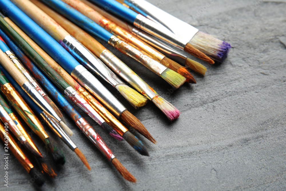 Fototapeta premium Different paint brushes on grey table, closeup