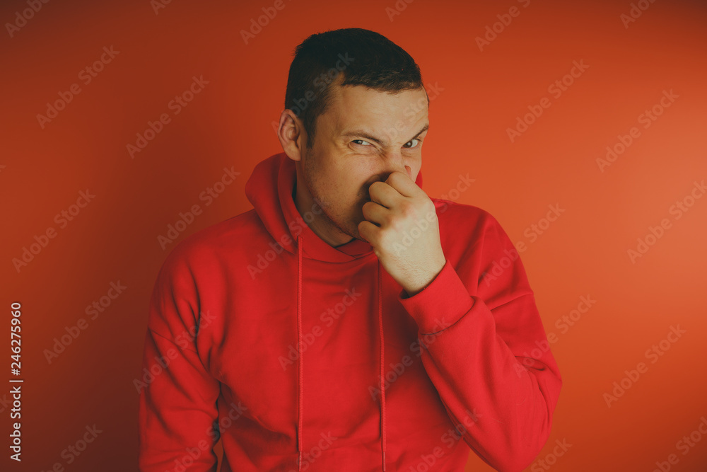 Crazy and charismatic guy posing on an orange background. A man in a red tracksuit. Crazy and charismatic guy posing on an orange background. A man in a red tracksuit.