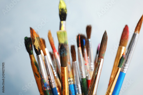 Different paint brushes on light background, closeup