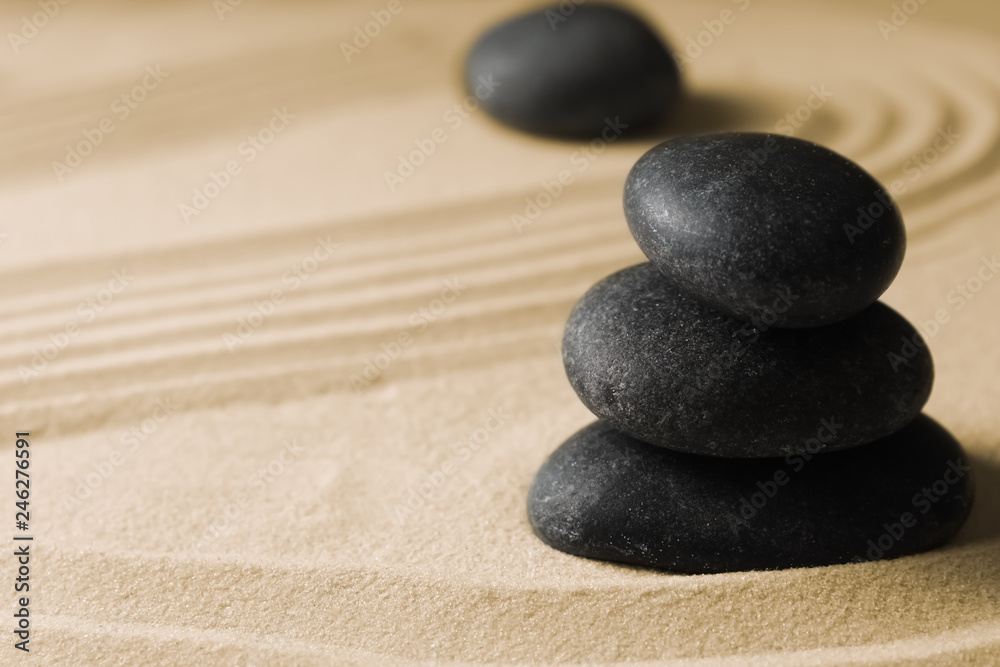 Stacked zen garden stones on sand with pattern, space for text. Meditation and harmony Stacked zen garden stones on sand with pattern, space for text. Meditation and harmony