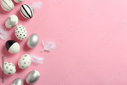 Painted Easter eggs on color background, flat lay with space for text