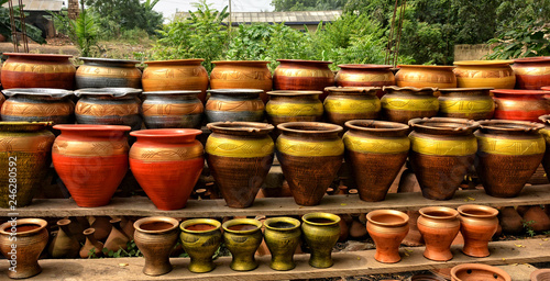 Clay pots stacked for sale on African roads. Pottery making place. Local craft market in Africa. Unique handmade colorful ceramic pots. Craftsmanship. African style.