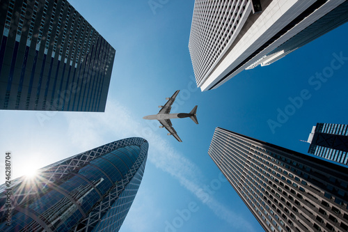 Canvas Print Tokyo skyscrapers buildings and a plane flying overhead at in Tokyo Shinjuku downtown and business district in morning at Tokyo, Japan